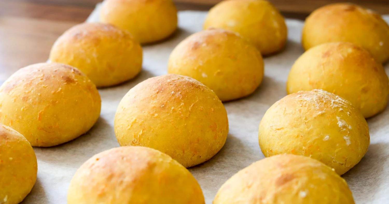 Porkkanasämpylöitä vierekkäin leivinpaperin päällä.