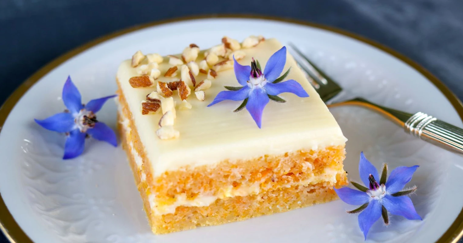 Gluteeniton porkkanakakku kurkkuyrtin kukilla koristeltuna.