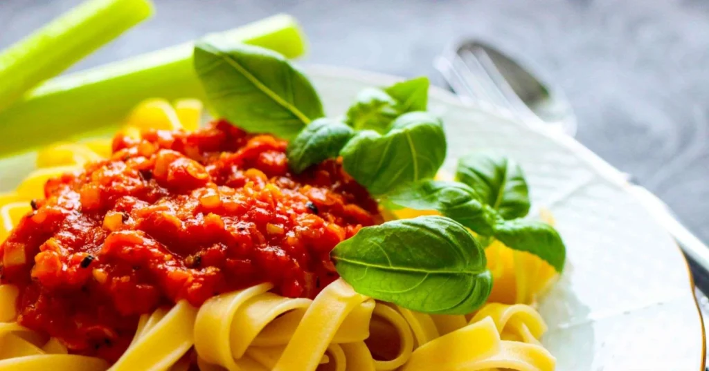 Punaista linssikastiketta tagliatelle-pastan päällä.