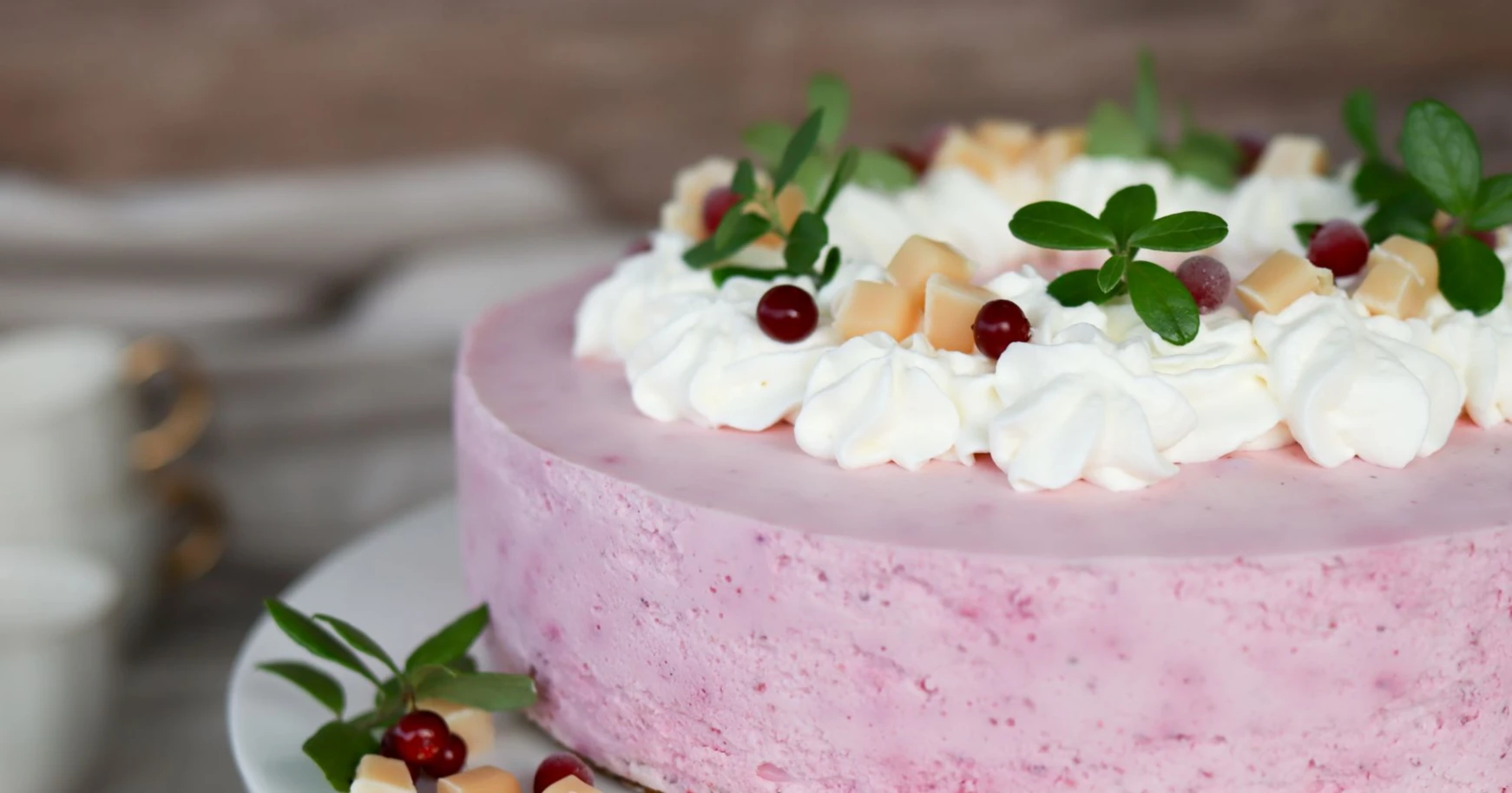 Puolukkajuustokakku kermavaahdolla ja toffeemakeisilla koristeltuna.