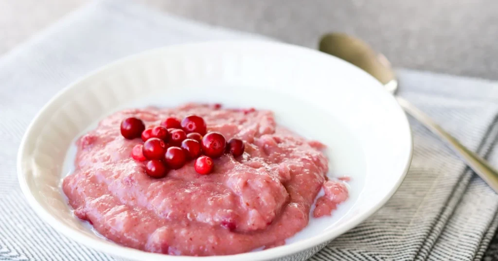 Puolukka-ruispuuro syvällä valkoisella lautasella.