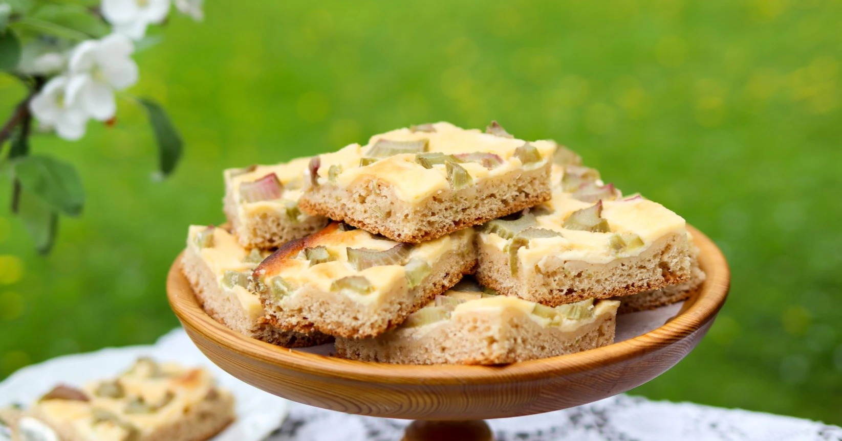 Raparperipiirakka tarjolla ulkona puisella tarjoiluvadilla.