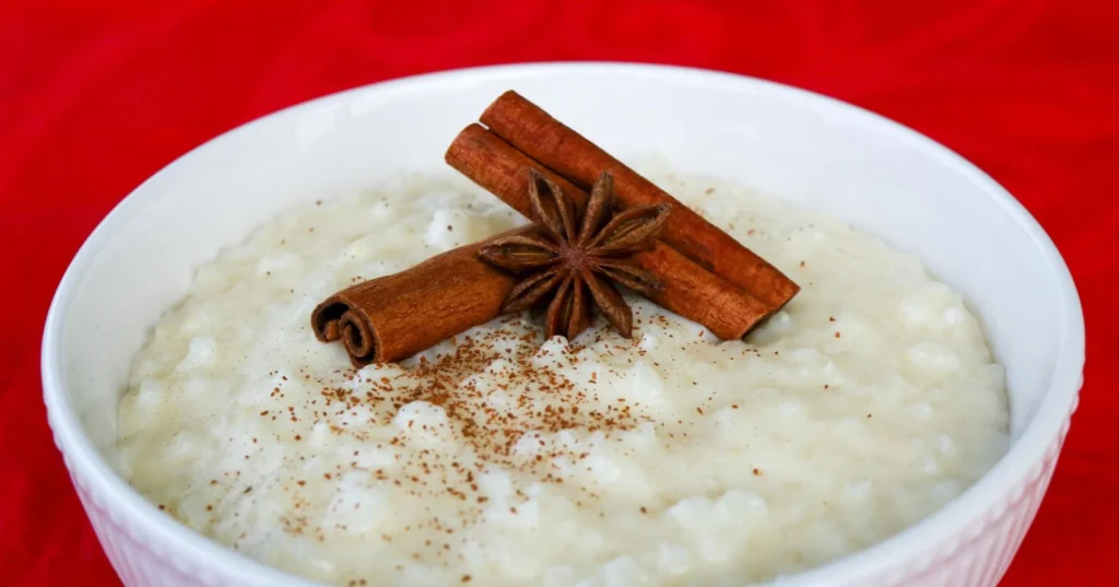 Riisipuuro, jonka päällä on kaksi kanelitankoa sekä tähtianis.