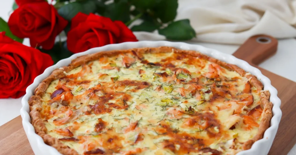 Savulohipiirakka juhlapöydässä valkoisessa piirakkavuoassa.