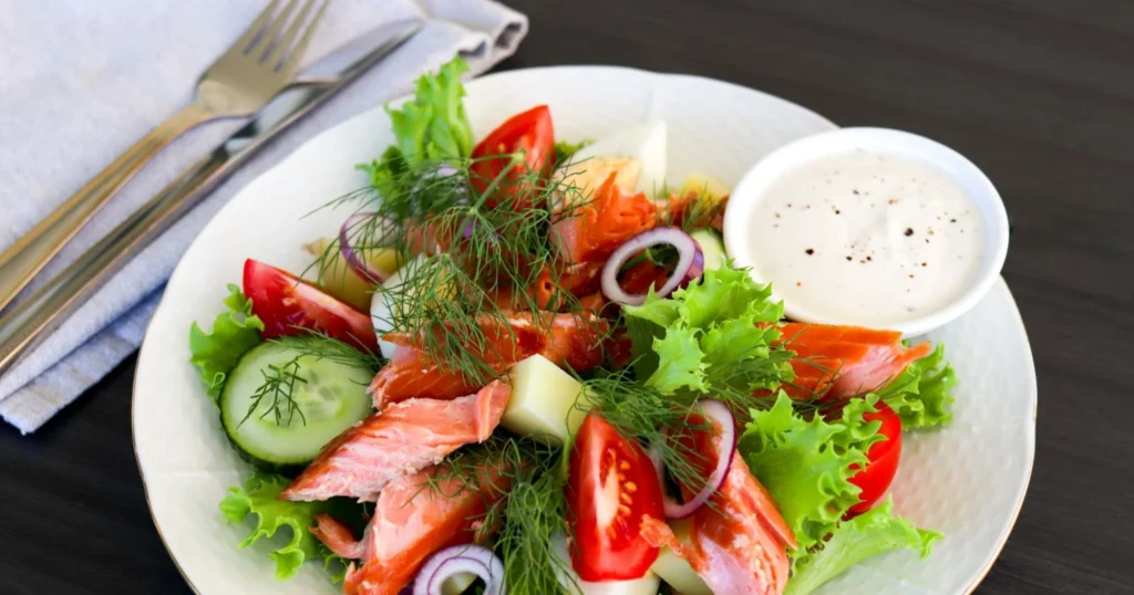 Savulohisalaatti tuoreella tillillä koristeltuna.