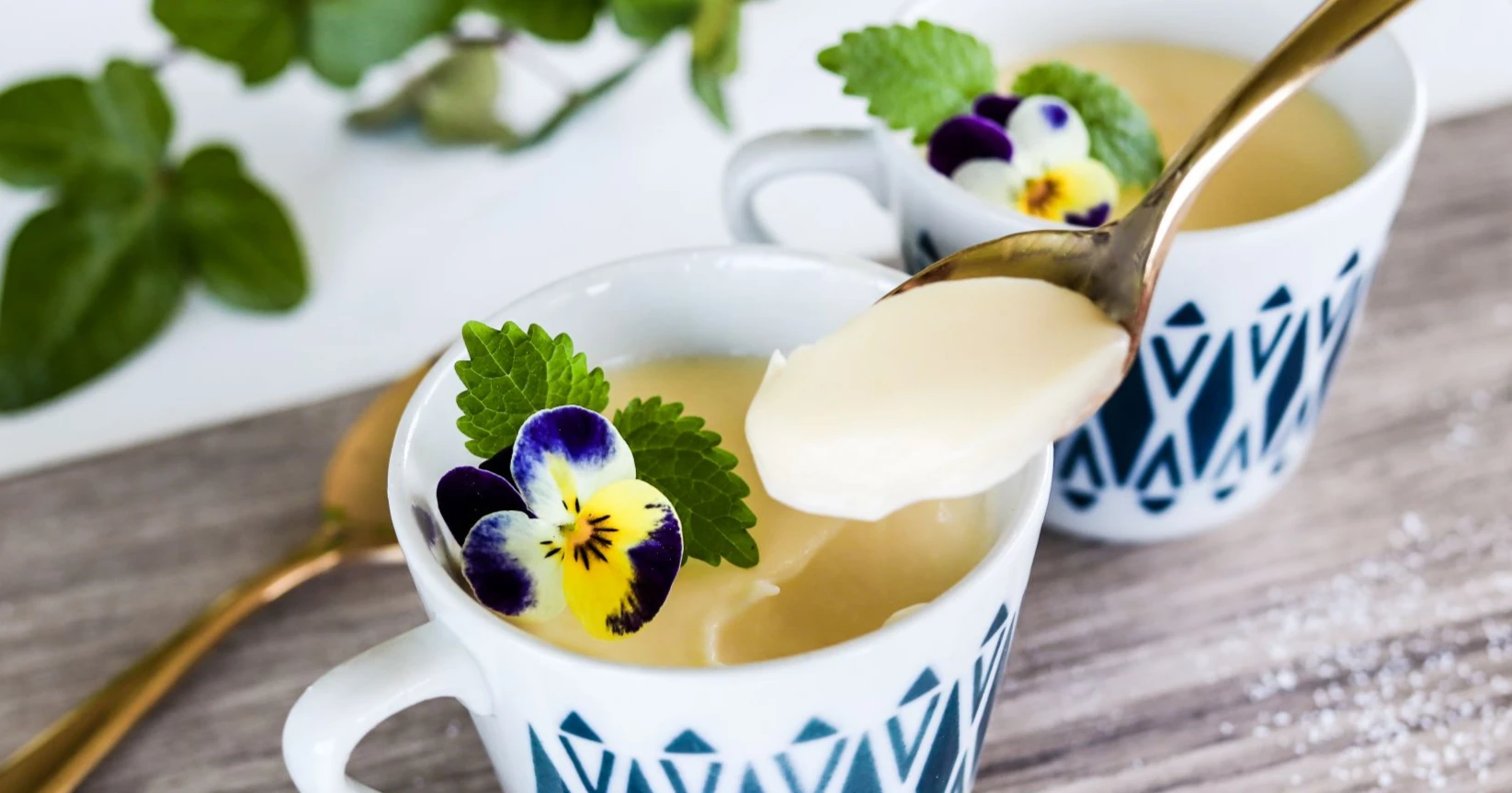 Sitruunaposset pienissä kahvikupeissa orvokeilla koristeltuna.