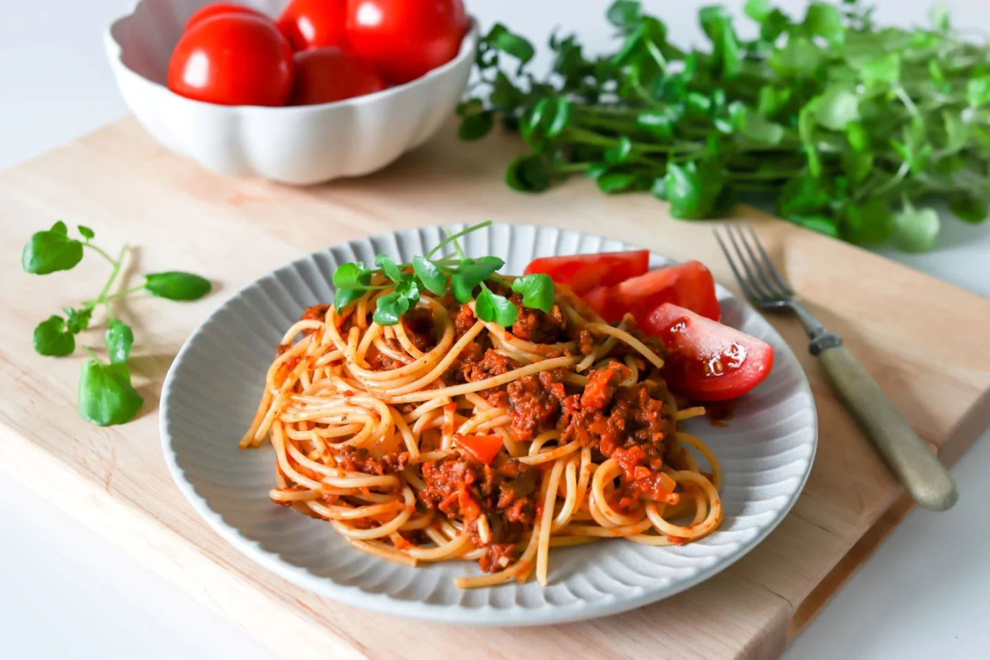 Soijabolognese kauniilla lautasella tuoreen tomaatin kanssa.