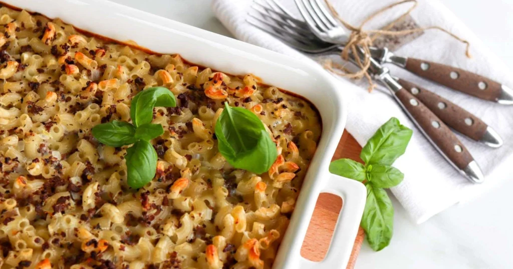 Soijamakaronilaatikko uunivuoassa basilikalla koristeltuna.