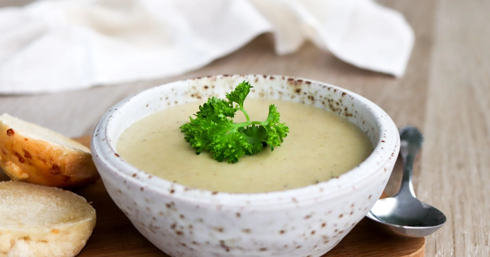 Soseutettu sienikeitto savesta tehdyssä kulhossa.