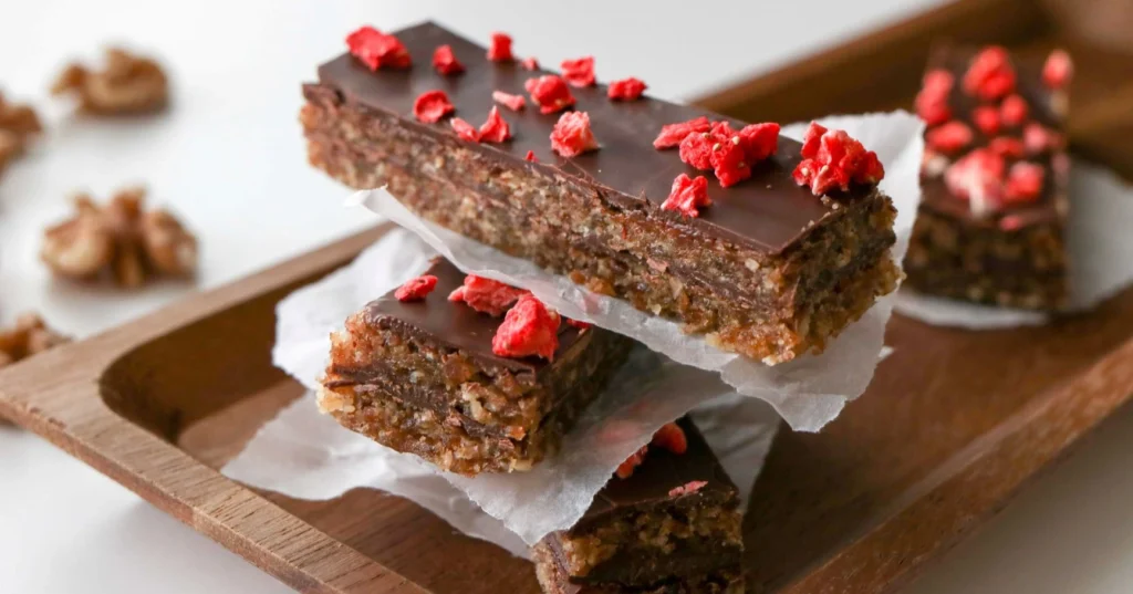 Suklaiset energiapatukat, joiden päällä on kuivattua vadelmaa.