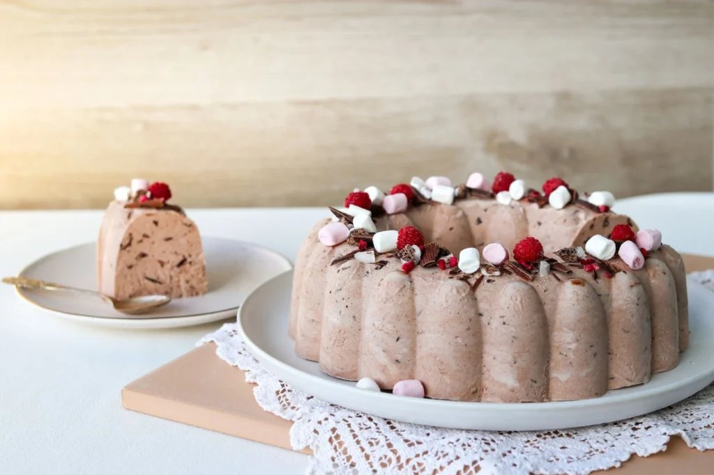 Suklaajäädyke vadelmilla ja rouhitulla suklaalla koristeltuna.