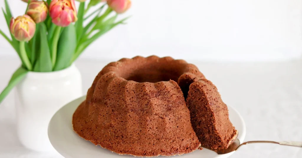 Suklaakahvikakku ja tulppaaneita maljakossa.