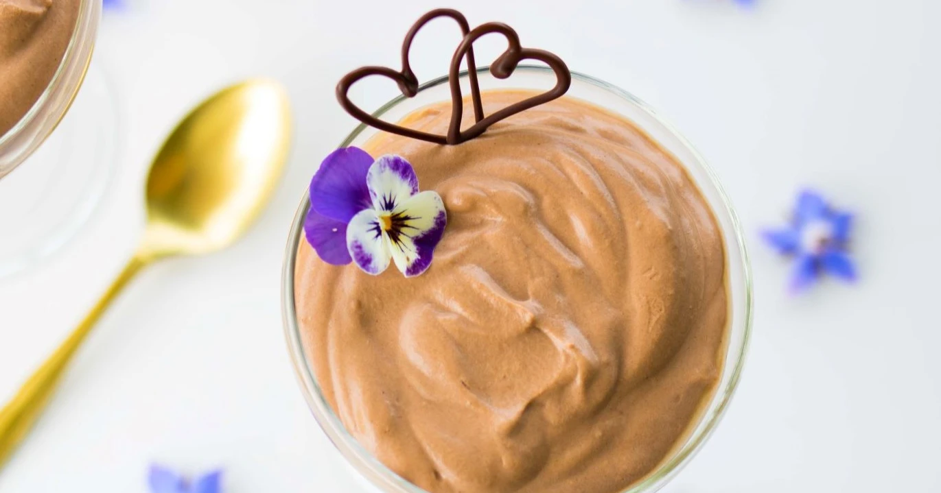 Suklaamousse sinisillä kukilla koristeltuna kulhossa.