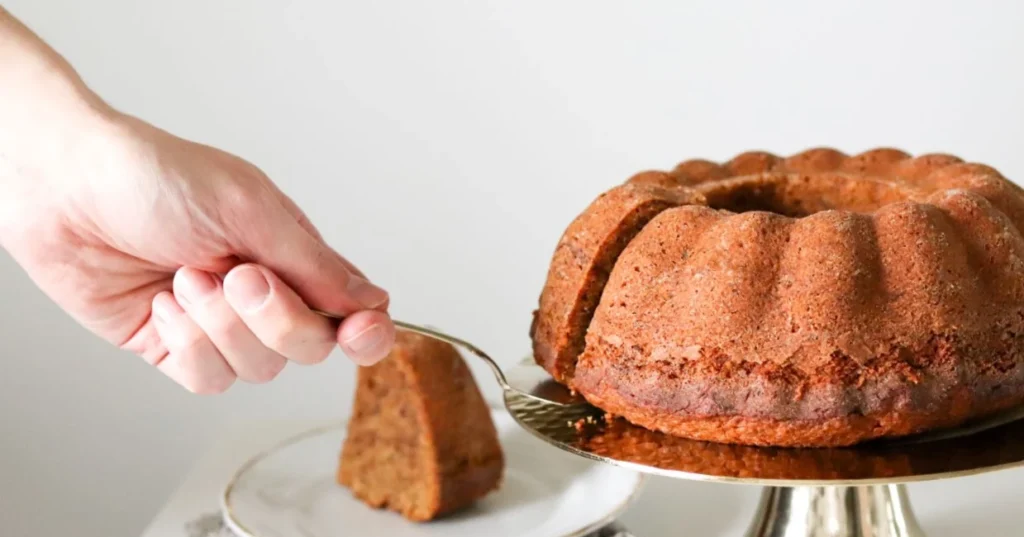 Taatelikakku, josta on leikattu pala kakkulapiolla.