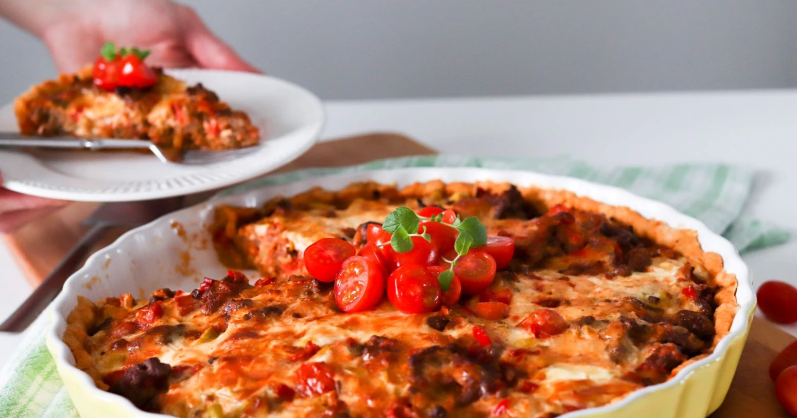 Texmex-piirakka, josta on leikattu pala pienelle lautaselle.