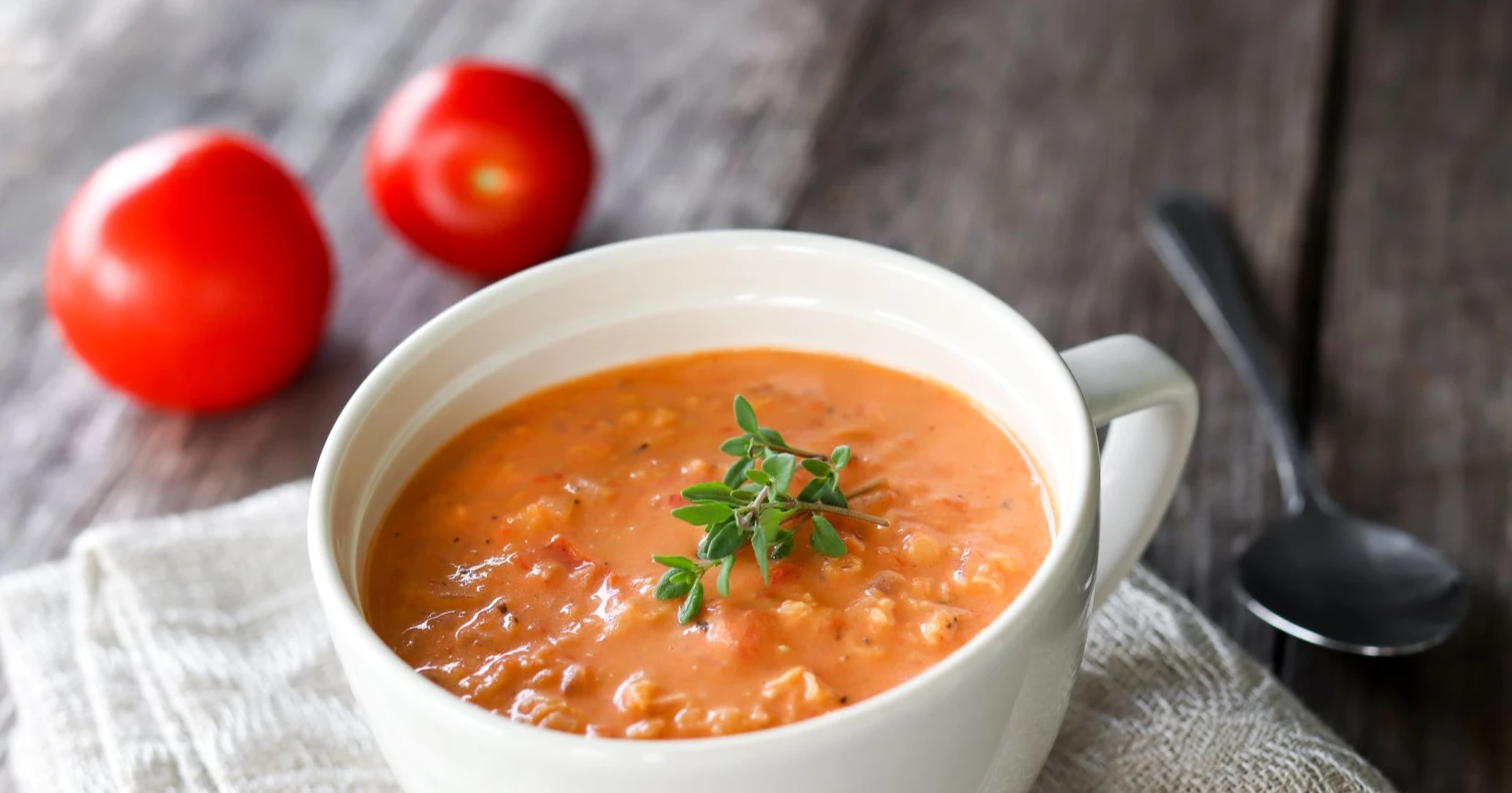 Tomaattinen linssikeitto isossa mukissa timjamilla koristeltuna.