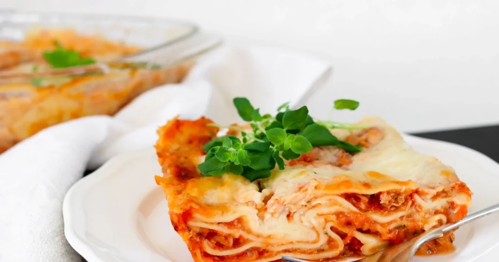 Tonnikalalasagnea lautasella tuoreella oreganolla koristeltuna.