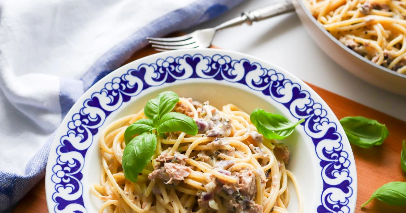 Tonnikalapasta lautasella, jossa on sinivalkoiset reunat.