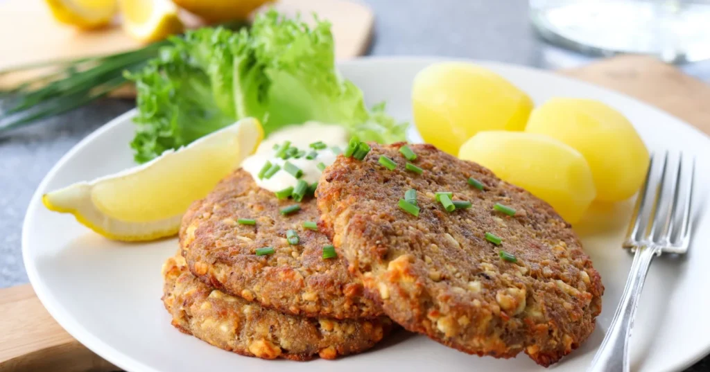 Tonnikalapihvejä ja perunoita ruokalautasella.