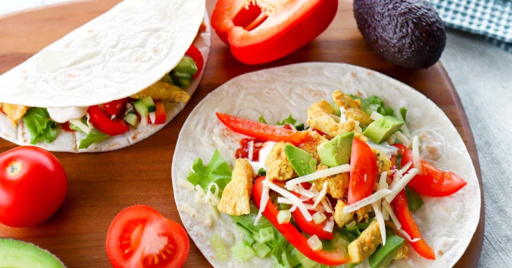 Tortilla kanan ja kasvisten kera leikkuulaudalla.