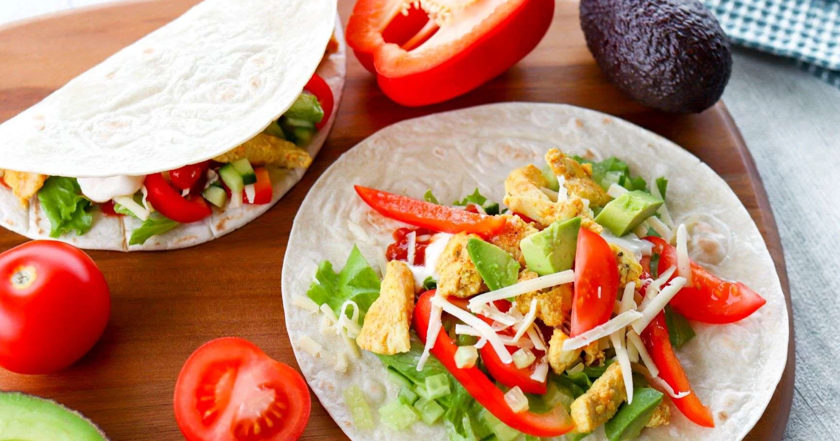 Tortilla kanan ja kasvisten kera leikkuulaudalla.