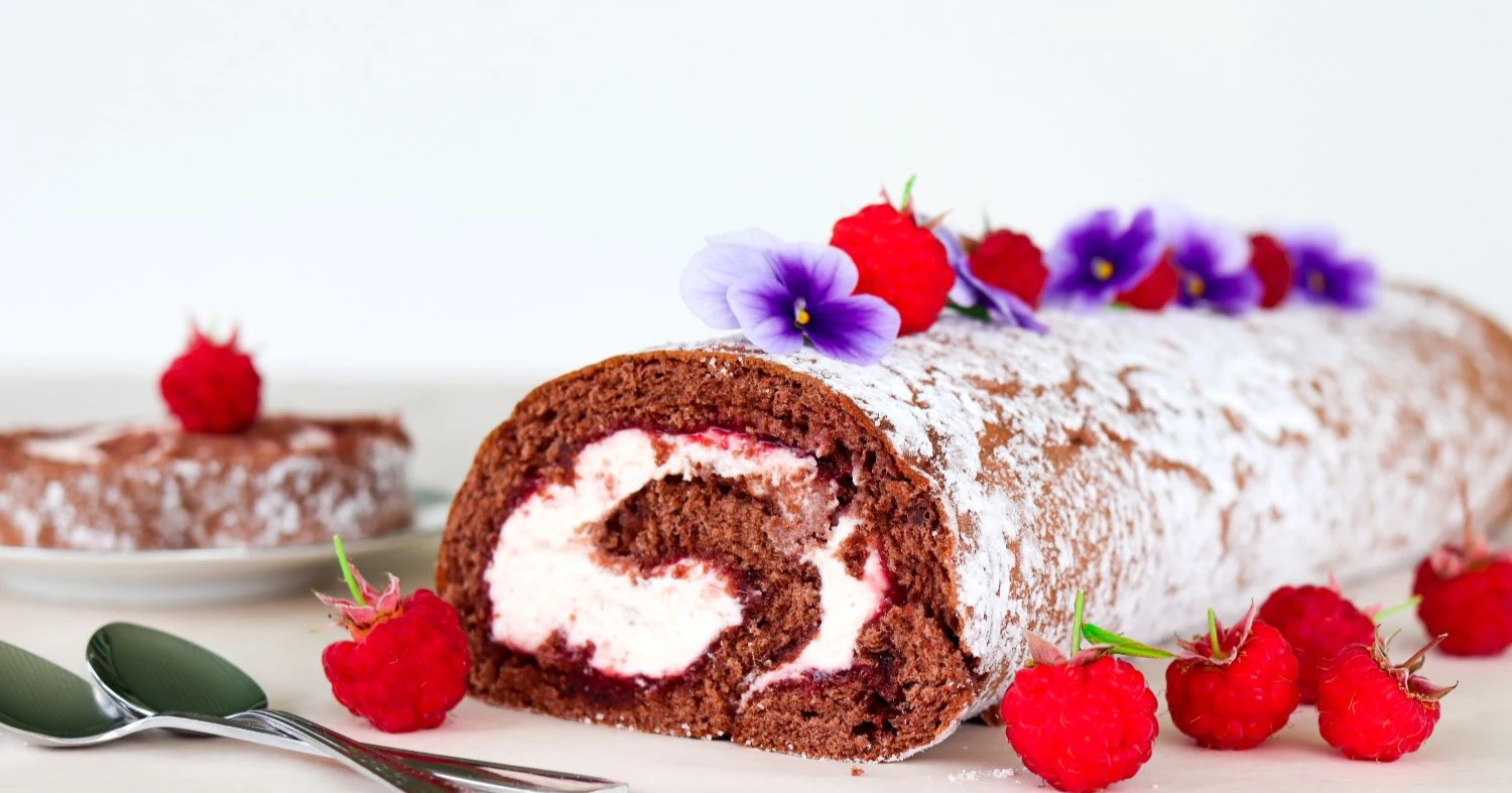 Vadelmakääretorttu tuoreiden vadelmien kera.