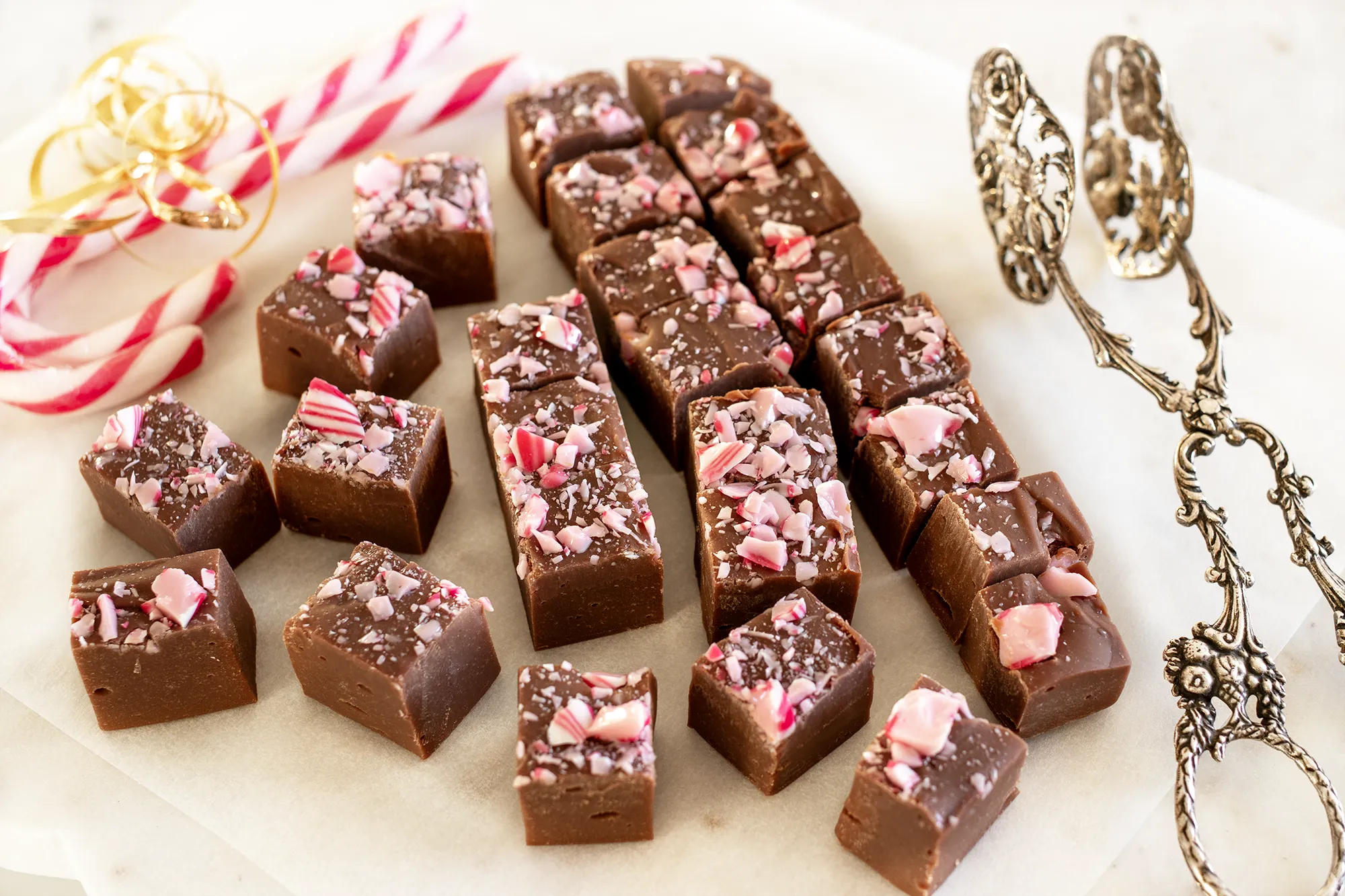 Suklaafudge paloiksi leikattuna ja karkkikeppejä.