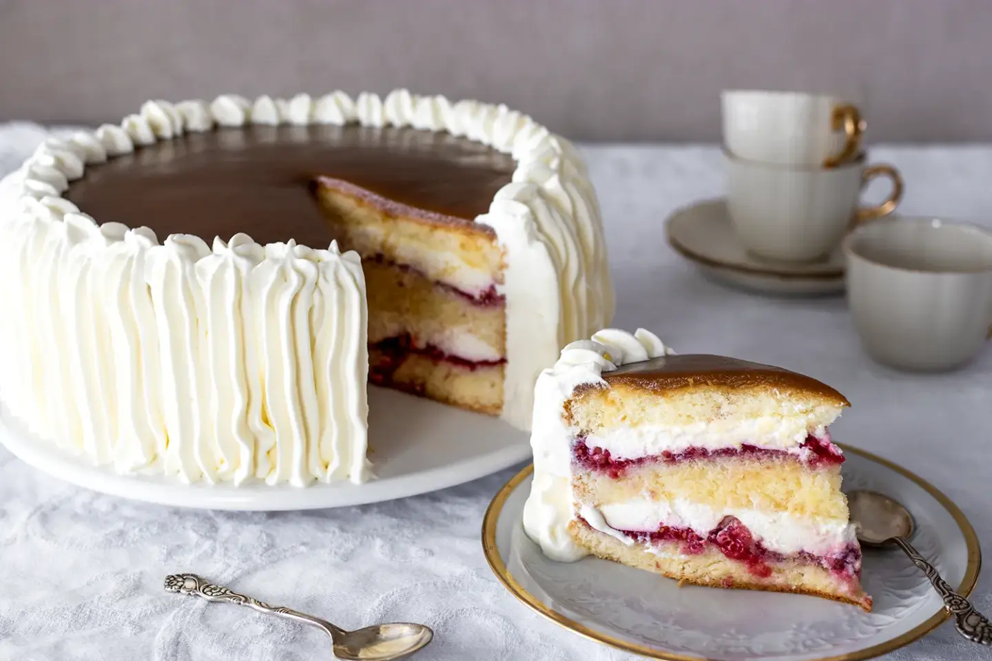 Kinuskikakku, joka on täytetty vadelmalla ja josta on leikattu pala.