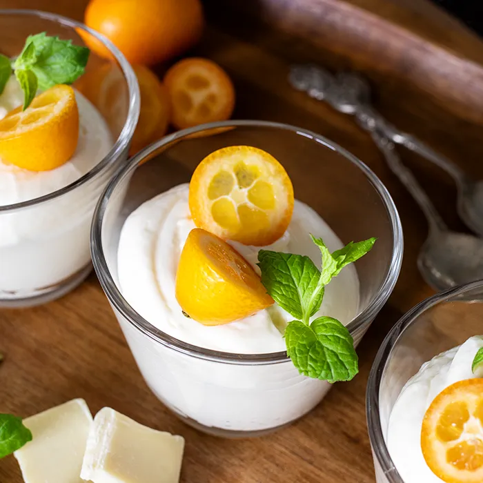 Valkosuklaamousse, jonka päällä on kumkvattia ka minttua.