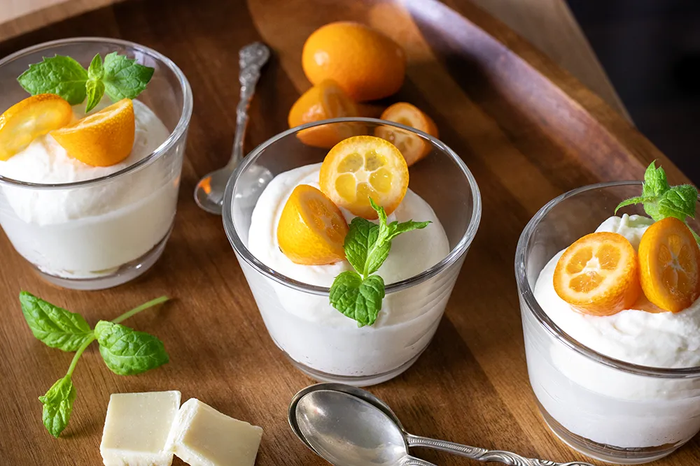 Valkosuklaamousse koristeltuna pienissä laseissa.