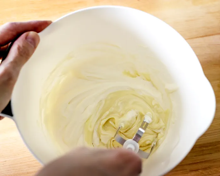 Valkosuklaamoussen sekoittaminen kulhossa.